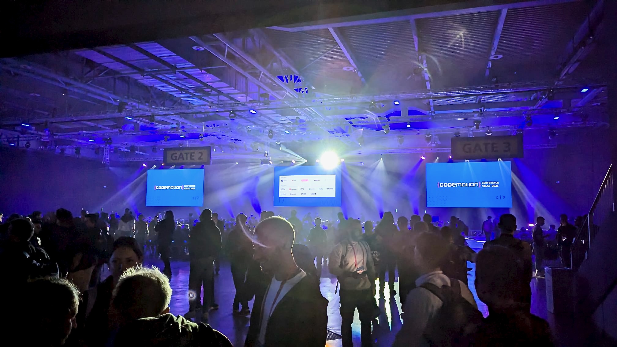 People walking and talking in the main hall of Codemotion Milan 2025 People walking and talking in the main hall of Codemotion Milan 2025
