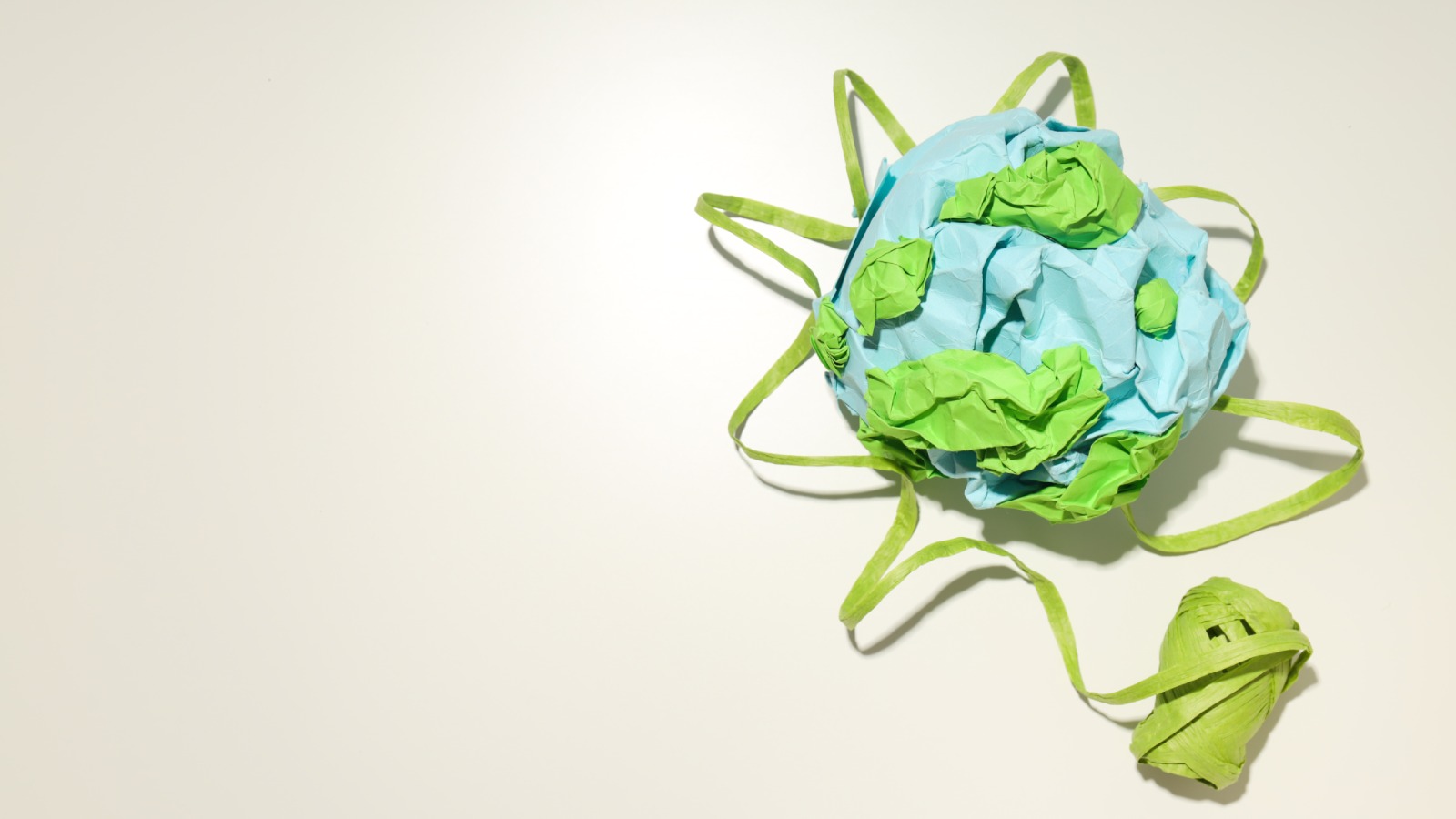 An artistic model of the Earth created with blue and green paper, emphasizing eco-friendly and sustainable practices.